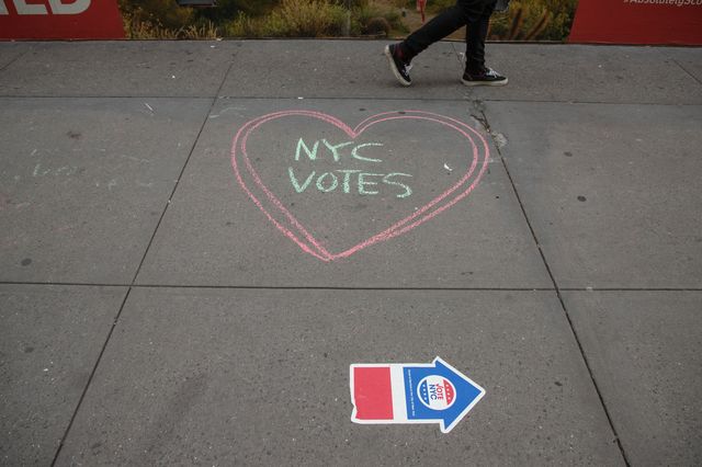 A pedestrian passes a chalked message near an early voting location at Madison Square Garden last October.